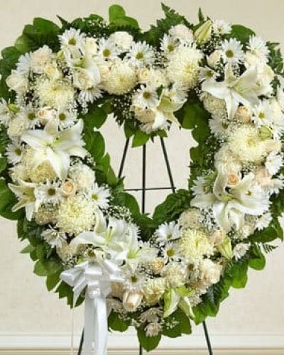 <p>Celebrate a beautiful life while expressing your most heartfelt sympathy. This exquisitely crafted, heart-shaped wreath is hand-arranged by our expert florists using the freshest white blooms to create a touching tribute to a special loved one who has passed. The arrangement features fresh white roses, lilies, carnations and more accented by baby's breath, salal and leather leaf and finished off with a satin ribbon. Traditionally sent directly to the funeral home by family members or friends and displayed on a stand.</p>
