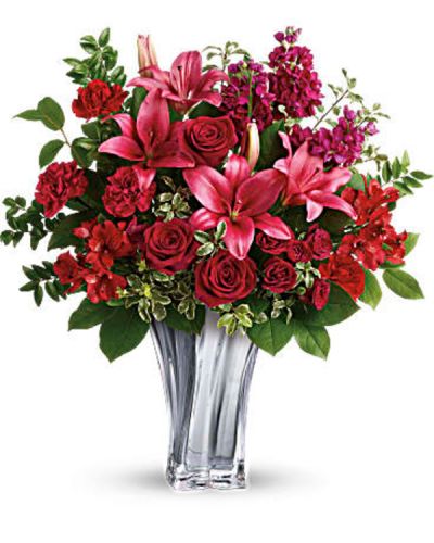 The epitome of romance, this breathtaking bouquet of red roses and pink lilies reaches a new level of luxury thanks to its elegant glass vase with sleek lines.
Red roses, dark red spray roses, dark pink asiatic lilies, red alstroemeria, and burgundy stock are arranged with lemon leaf, huckleberry, and pitta negra.