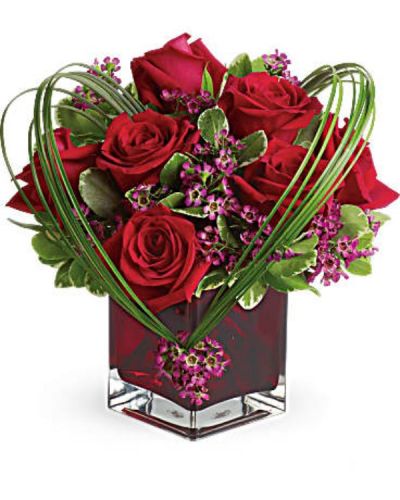 You'll love the Sweet Thoughts bouquet, and you'd like to make a big impression. Send this premium version, and they'll know they've got your heart! With more roses - but the same classic, collectible cube vase in a shade of warmest crimson - this gift will be a surefire hit.
A deluxe mix of red roses and purple waxflower - accented with bear grass and greenery - is delivered in a red glass cube vase.
