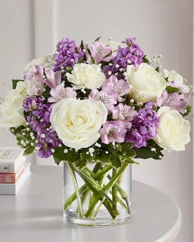 Lovely memories are made with thoughtful gifts for the ones we care about. Our charming bouquet is loosely gathered with a medley of lavender & white blooms. Hand-designed inside a clear cylinder vase with cascading greenery all around, it’s a wonderful way to express the sentiments you have inside your heart.